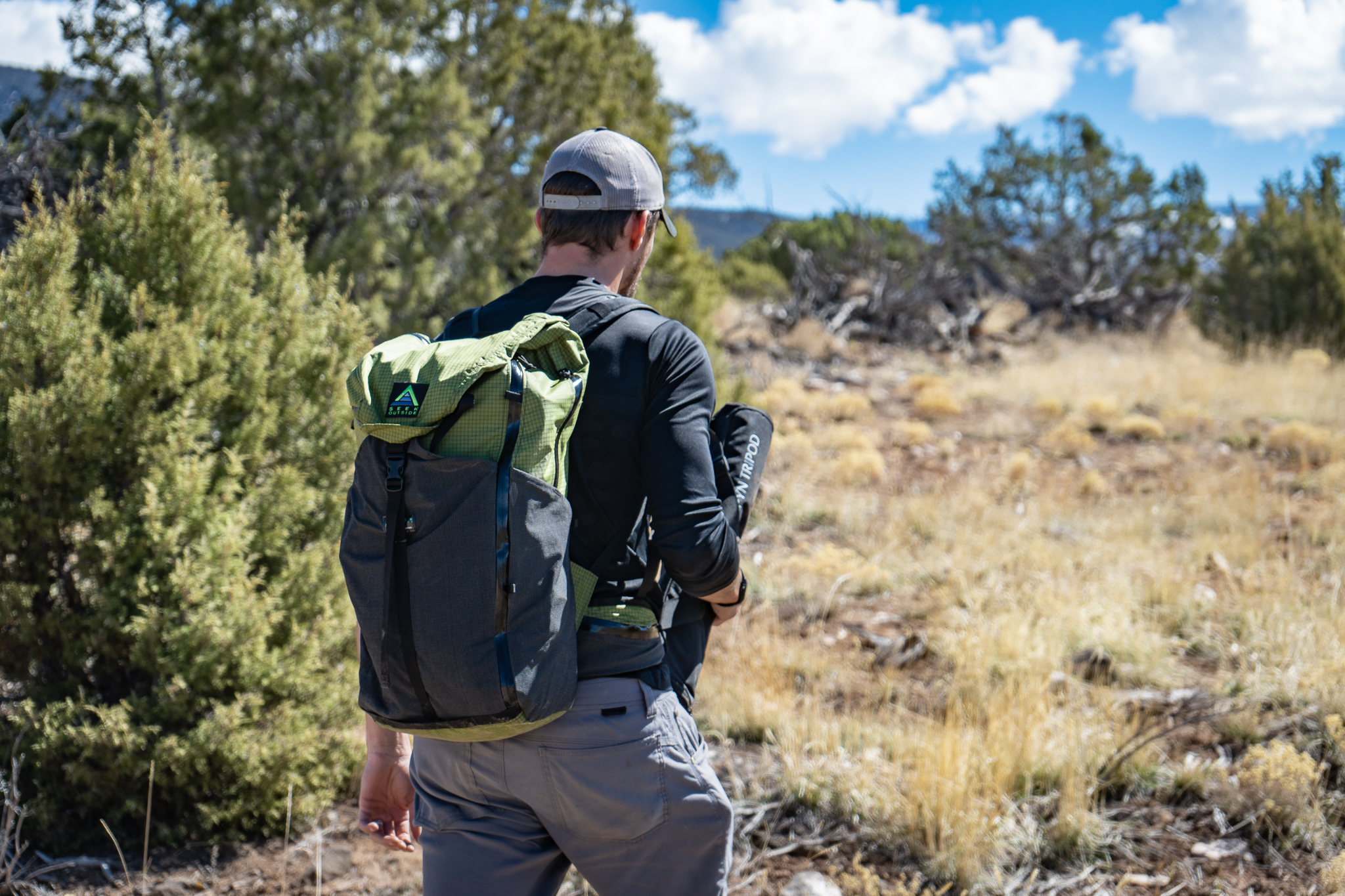 hiker walks through sagebrush wearing a lightweight seek outside backpack
